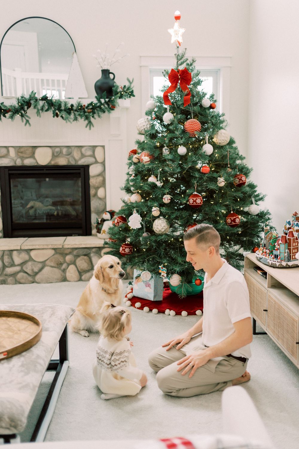 Festive Christmas scene with decorated tree, Golden Retriever and pets by the fireplace.