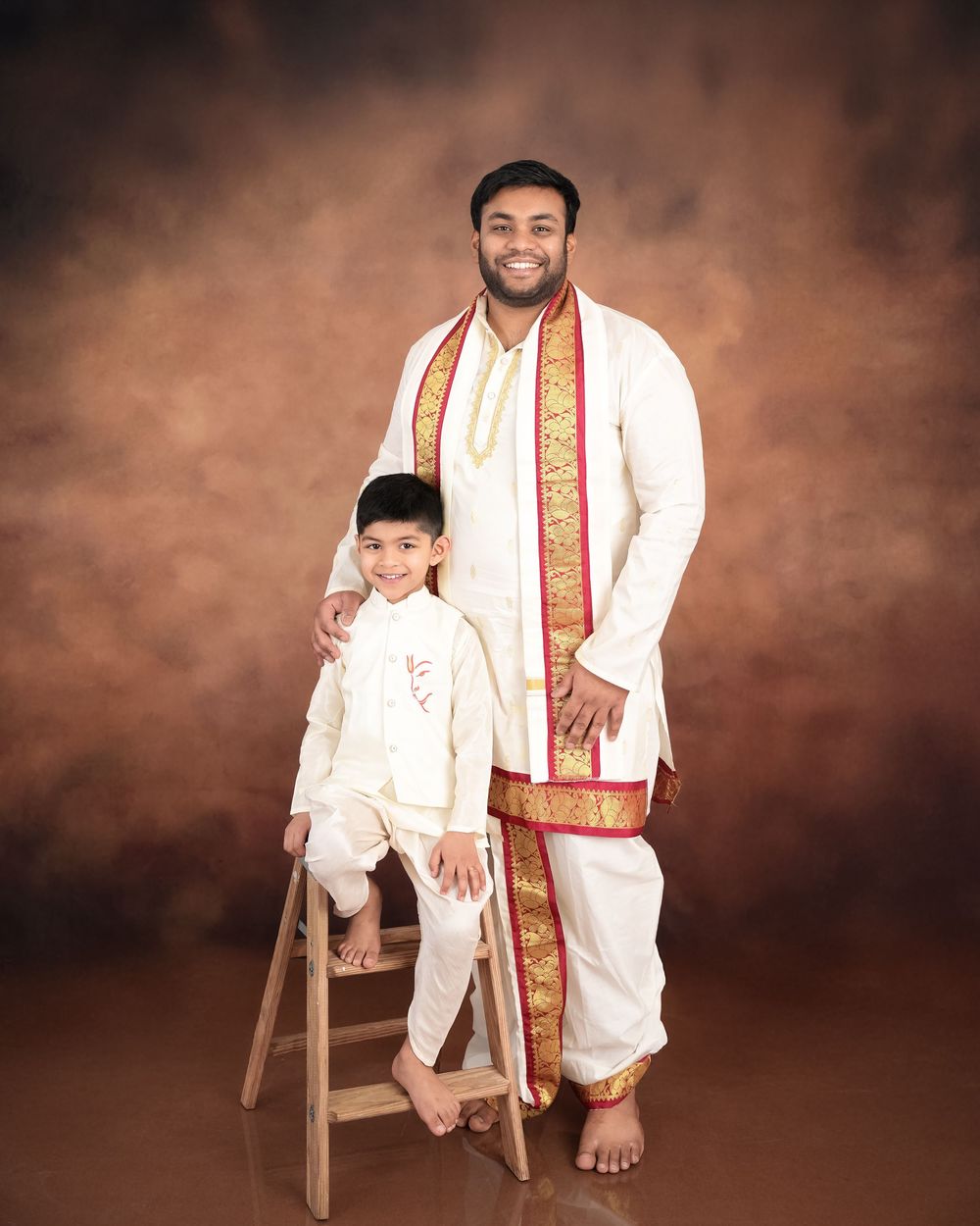Traditional South Asian portrait in white and gold formal attire.