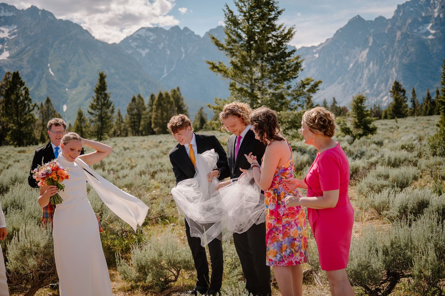 A joyous celebration in Grand Teton National Park with mountain peaks and evergreen trees creating a stunning backdrop.