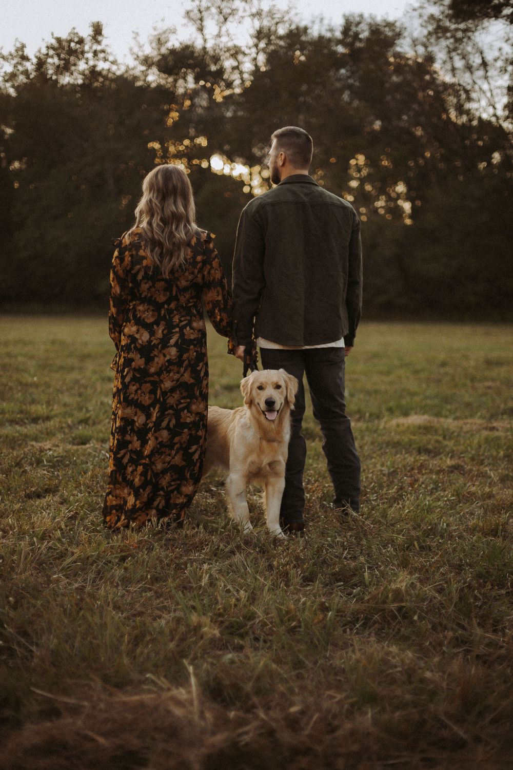 couple photographed with golden retriever dog in golden hour photoshoot in North Alabama