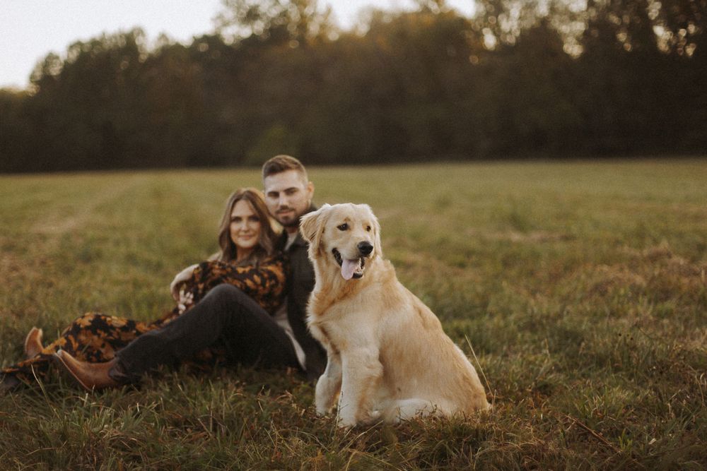 couple photographed with golden retriever dog in golden hour photoshoot in Alabama