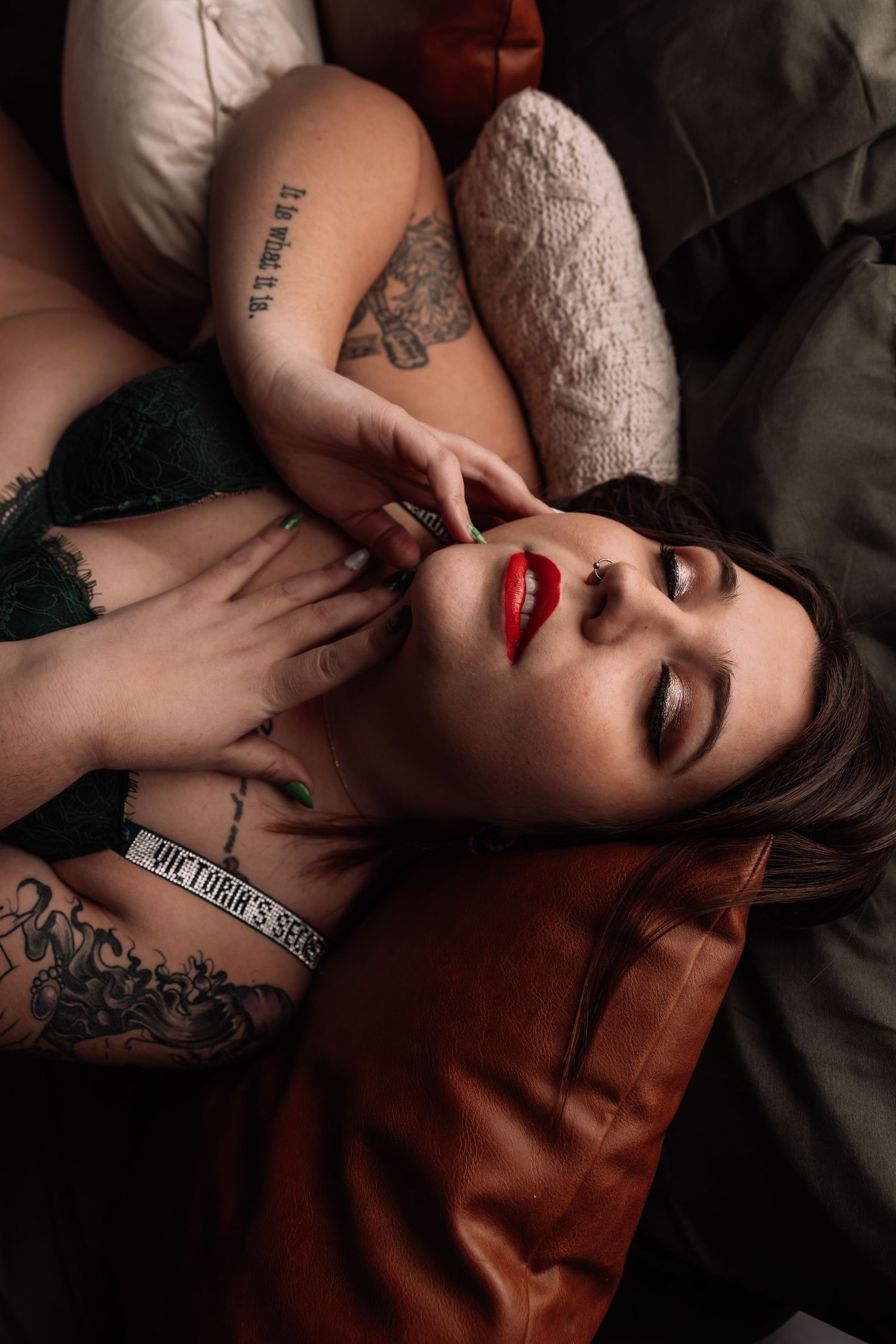 Studio Boudoir Photoshoot
Artistic portrait photograph featuring bold red lipstick, tattoos and dramatic lighting on a dark leather couch.