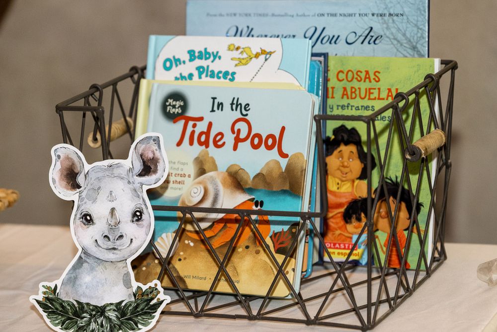 Children's books and a plush bunny displayed in a decorative wire basket.
