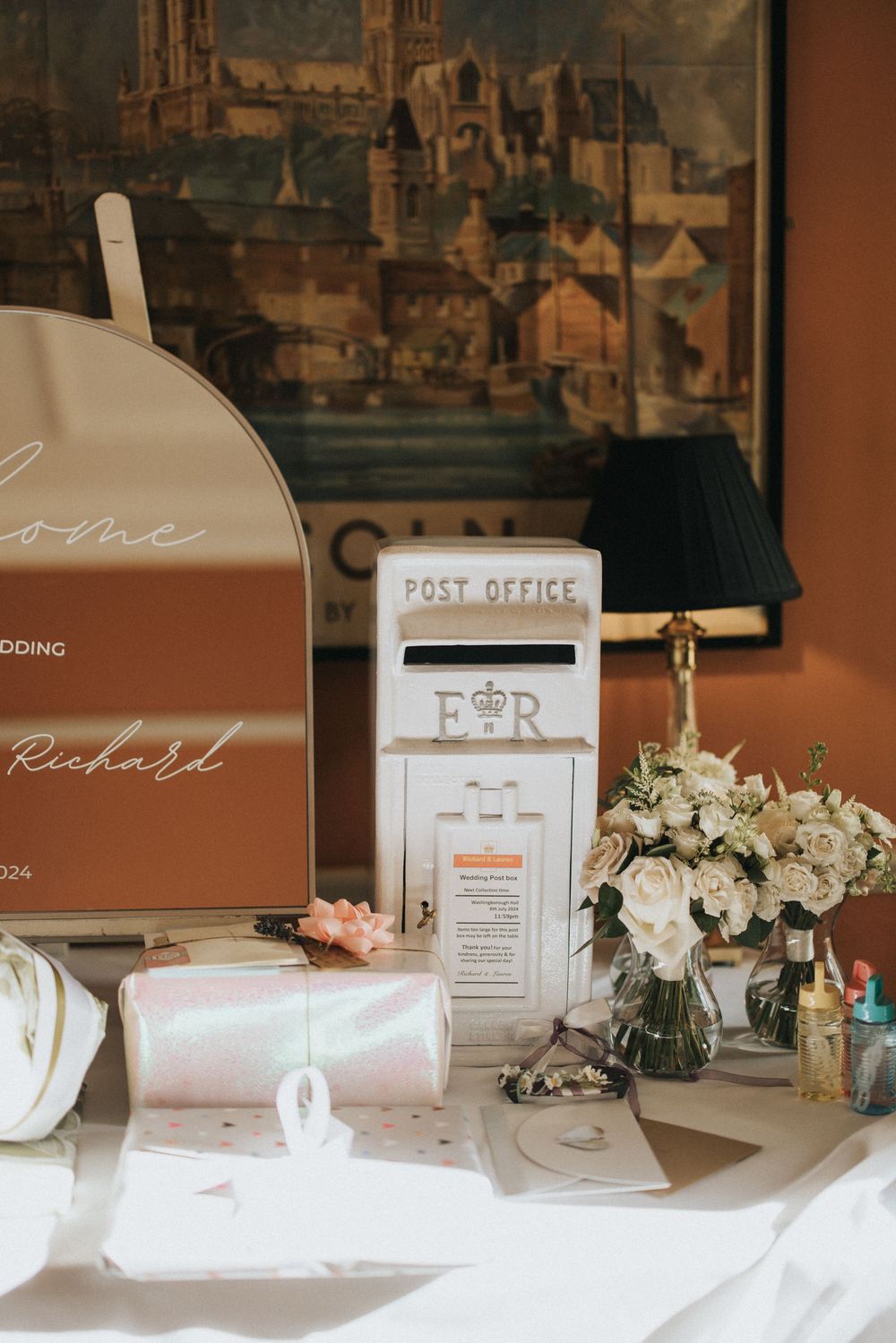 Wedding reception table displays with post office boxes and vintage-style signs in muted brown and white tones at Washingborough Hall.