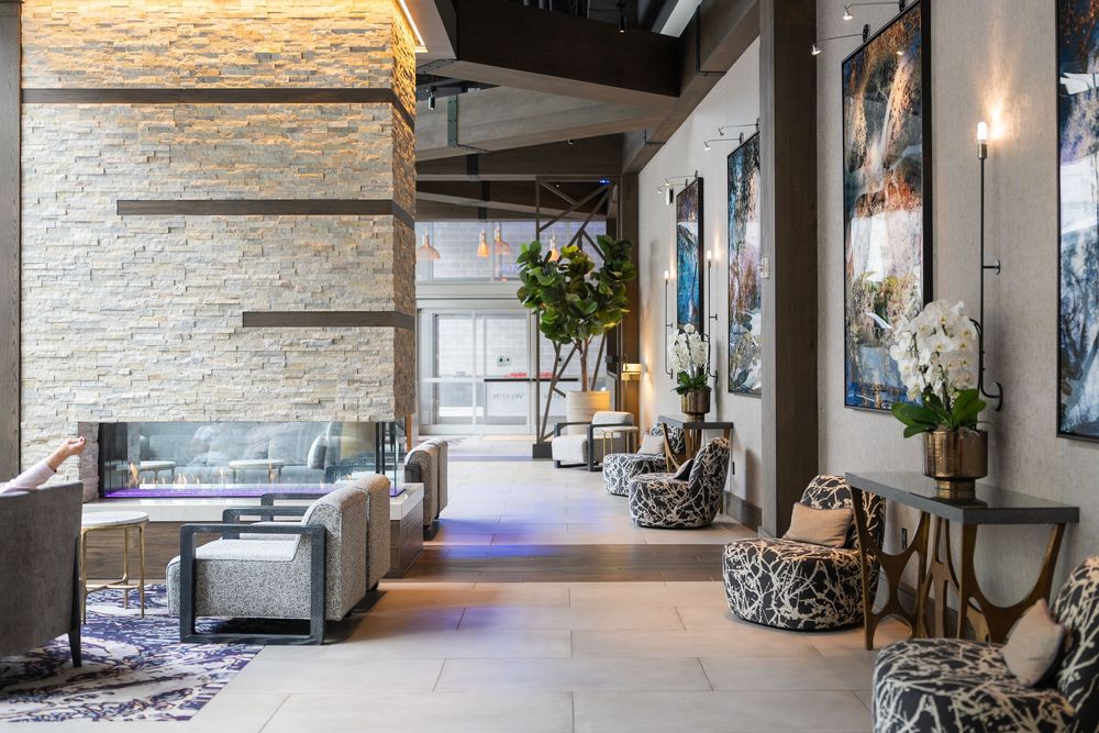 Modern upscale hotel lobby with stone accent walls, sleek furniture, and contemporary lighting fixtures creates a welcoming atmosphere.
