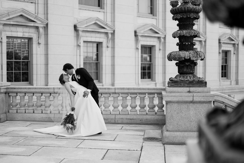 A person in a wedding dress and veil poses for photos at Union Trust building's outdoor terrace in Philadelphia.