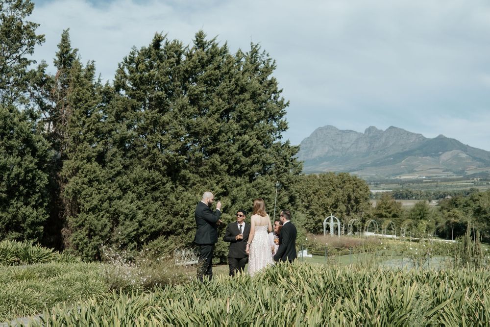 Beautiful outdoor wedding ceremony in hawaiian fields with mountains in background and lush greenery.