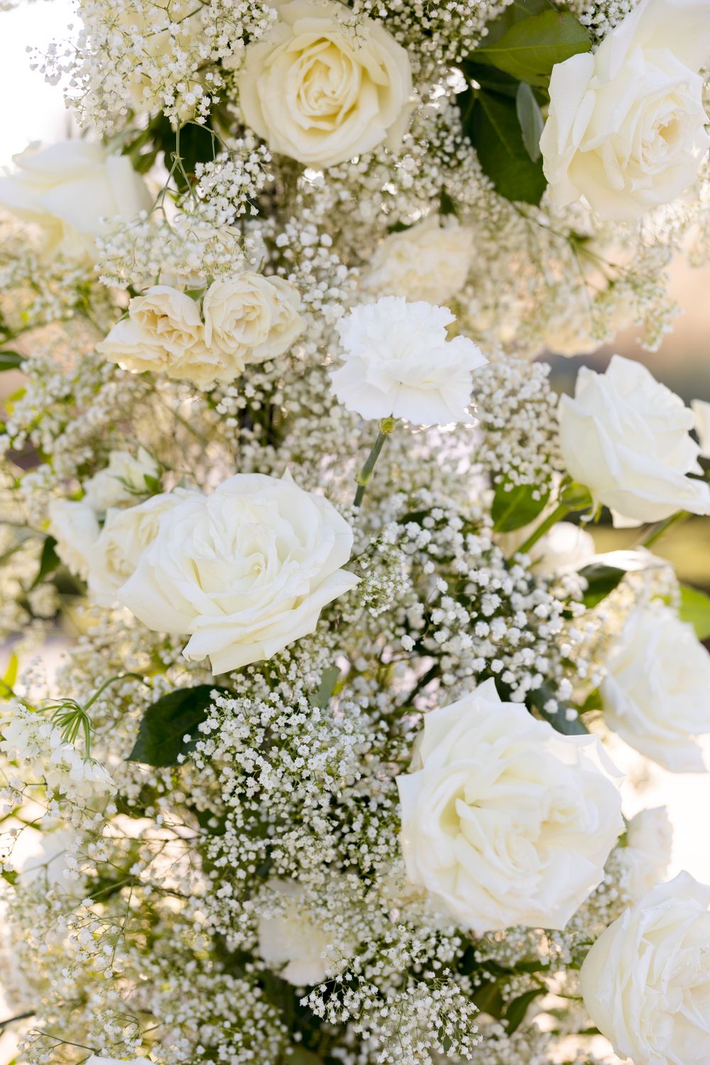 Elegant white rose and baby's breath floral arrangements displayed in a delicate decorative pattern.