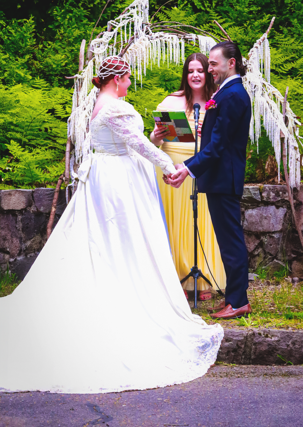 A wedding couple sharing intimate moments along a rustic stone wall path surrounded by greenery.
