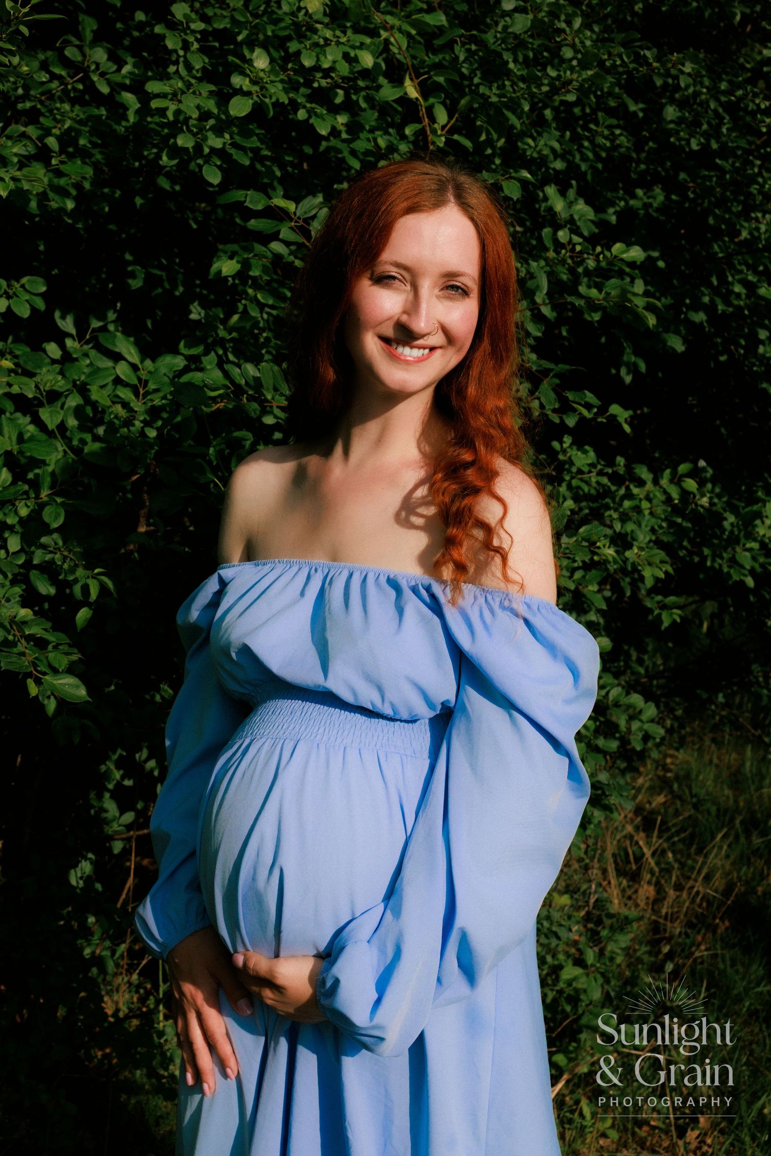 smiling red head pregnant woman in blue dress ,vivid colour, Norfolk , natural lighting. maternity session