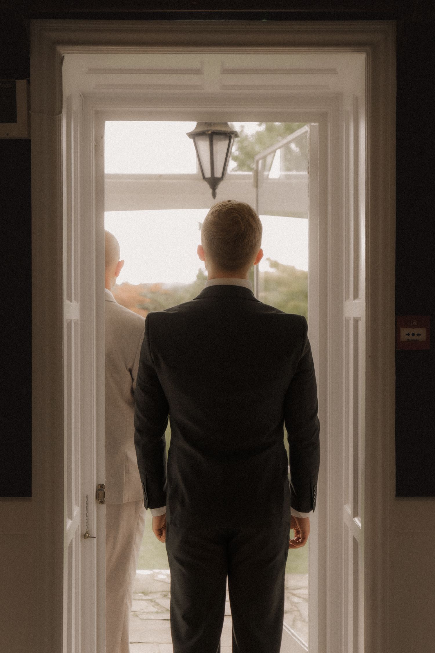 Groom standing in a bright doorway at Lindeth Howe Hotel wedding venu in Windermere