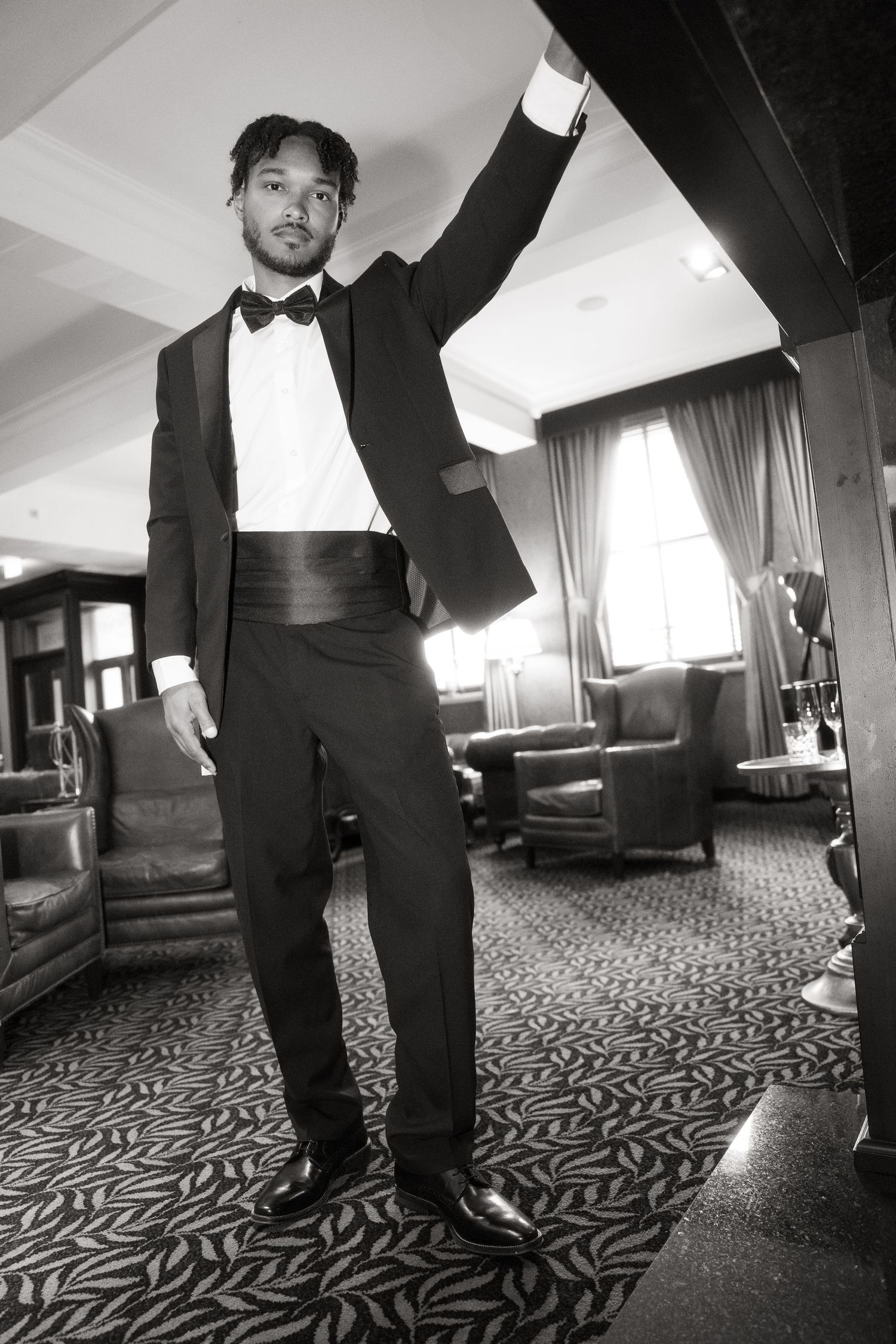 Black and white photos showing feet in dress shoes walking on a patterned hotel carpet from multiple artistic angles.