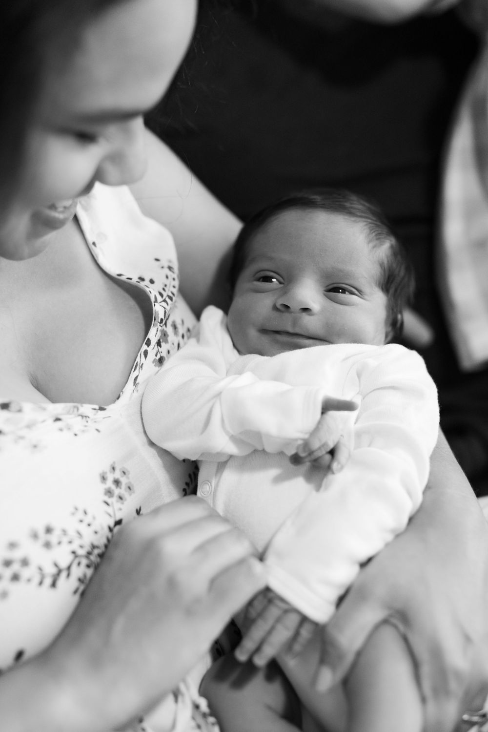 Black and white close-up photo montage of tender intimate moments between parent and newborn baby.