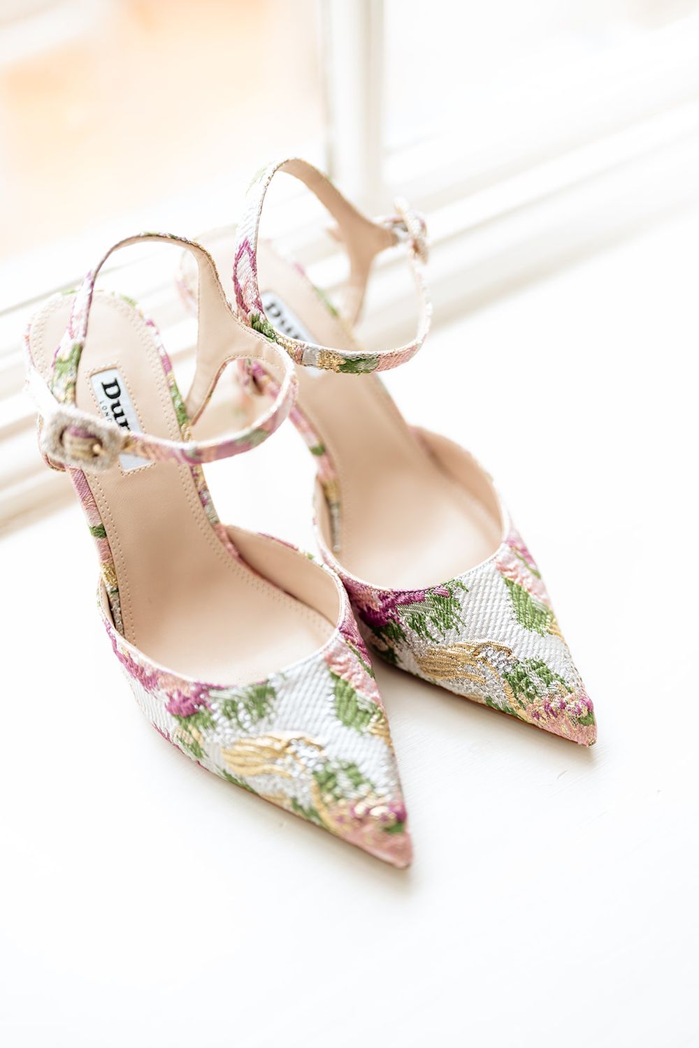 Elegant floral print kitten heel slingback pumps with pink and green botanical pattern on light background.