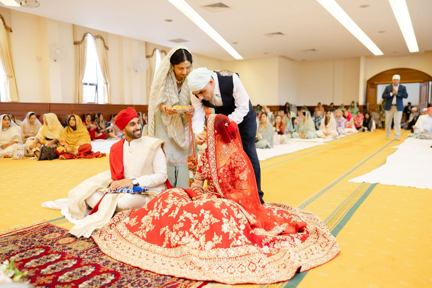 Bride's parents feeding the newlyweds in Hounslow Gurdwara