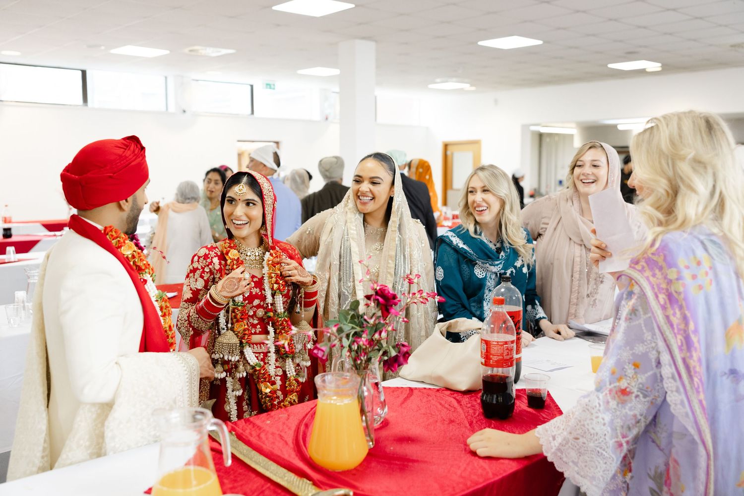 Candid moment of happy bride and groom with their guests in Hounslow Gurdwara