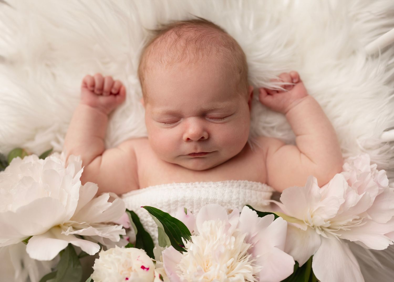 Sweet baby sleeps on a white fluffy blanket in a vintage crib surrounded by beautiful fresh peonies. Surrey BC.