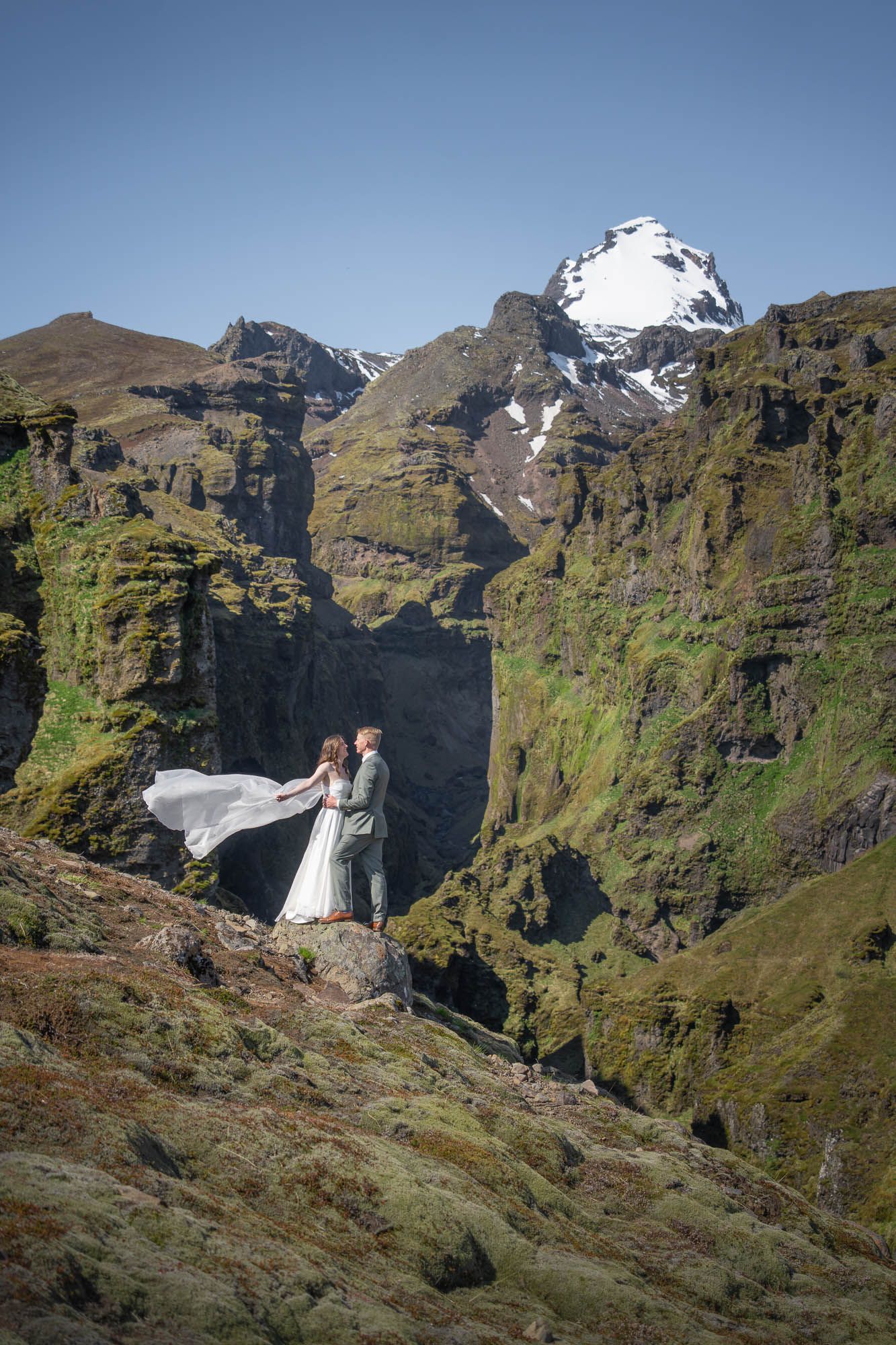 Stunning mountainous landscape with steep cliffs, snow patches, and green slopes in Iceland.