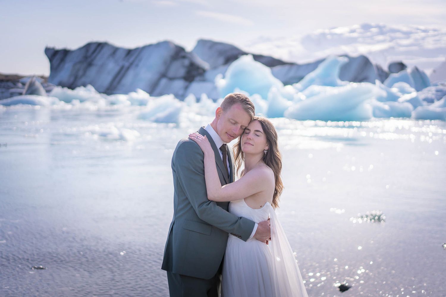 A romantic moment between newlyweds against a backdrop of majestic blue glaciers in Iceland.