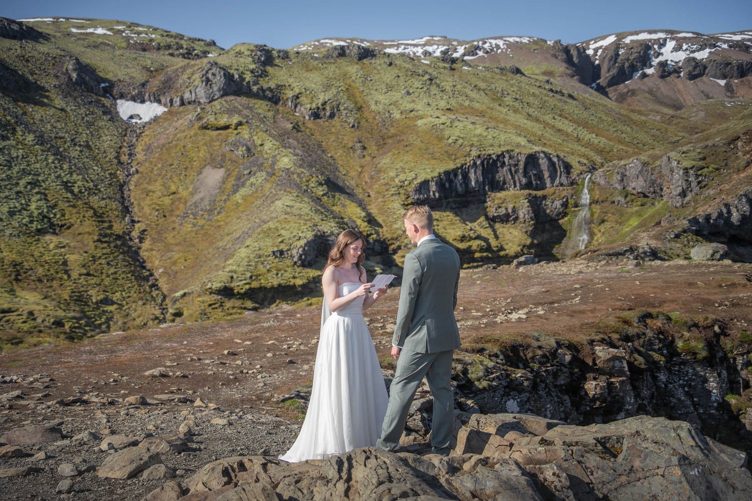 Couple sharing an intimate moment on a dramatic mountain cliff with gorgeous rocky terrain.
