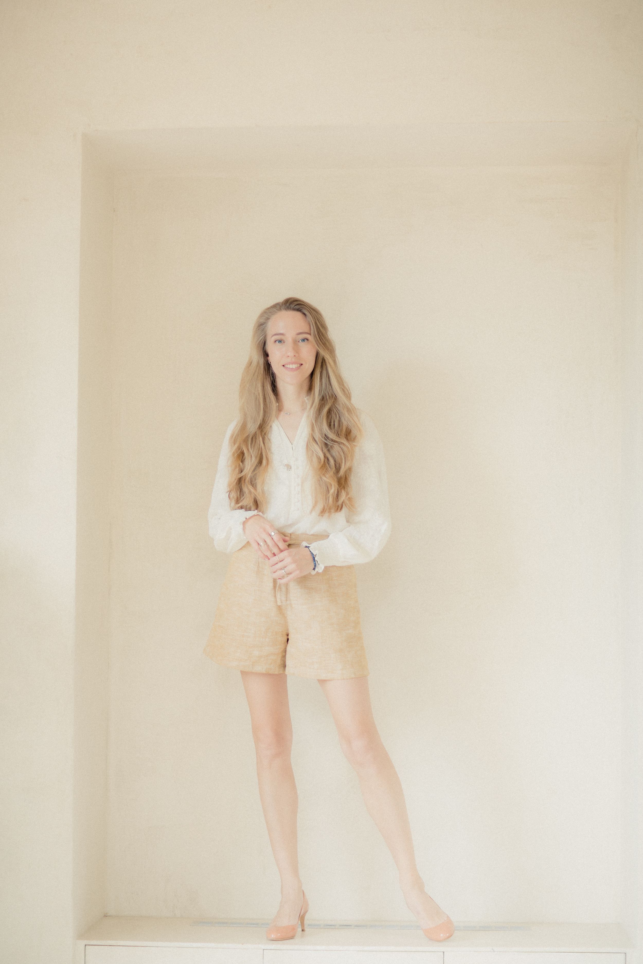 A series of soft, minimalist portraits showing a figure in beige clothing against a light neutral background.