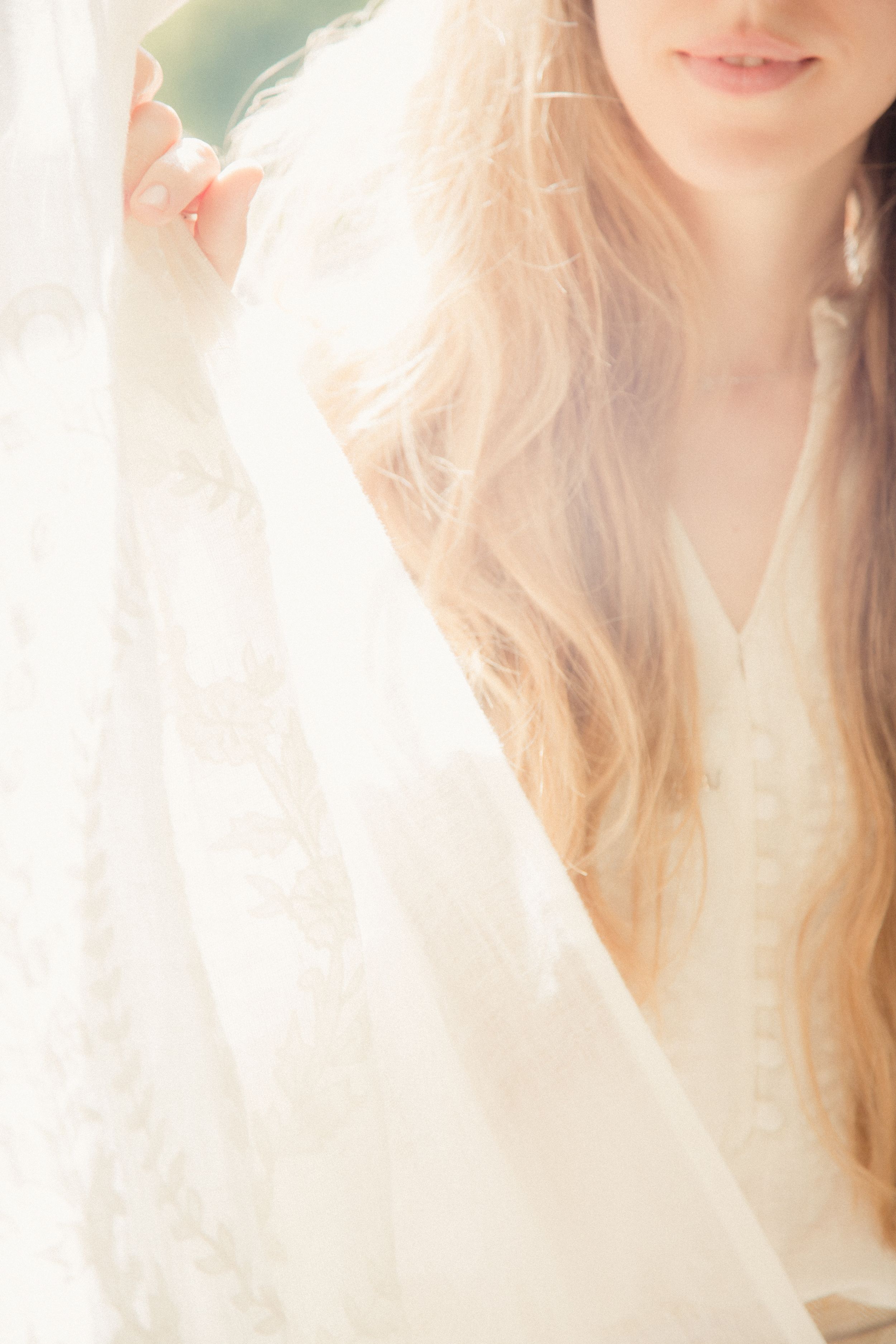 Dreamy ethereal portrait with flowing blonde hair and white clothing in soft natural light.
