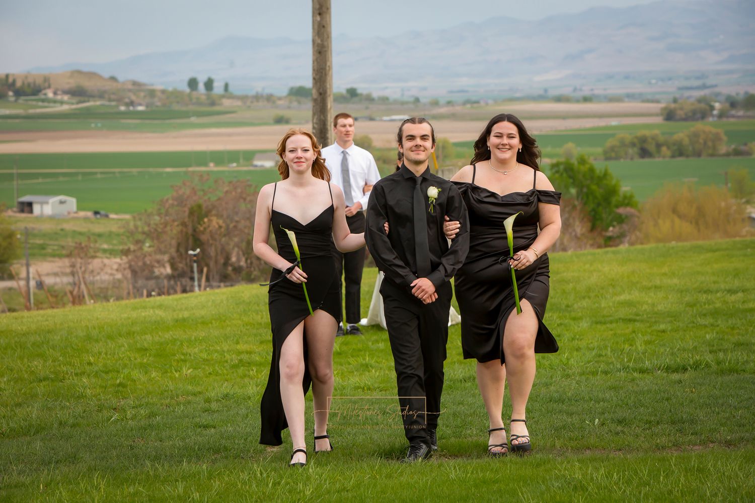 one groomsman with 2 bridesmaids in formal black attire