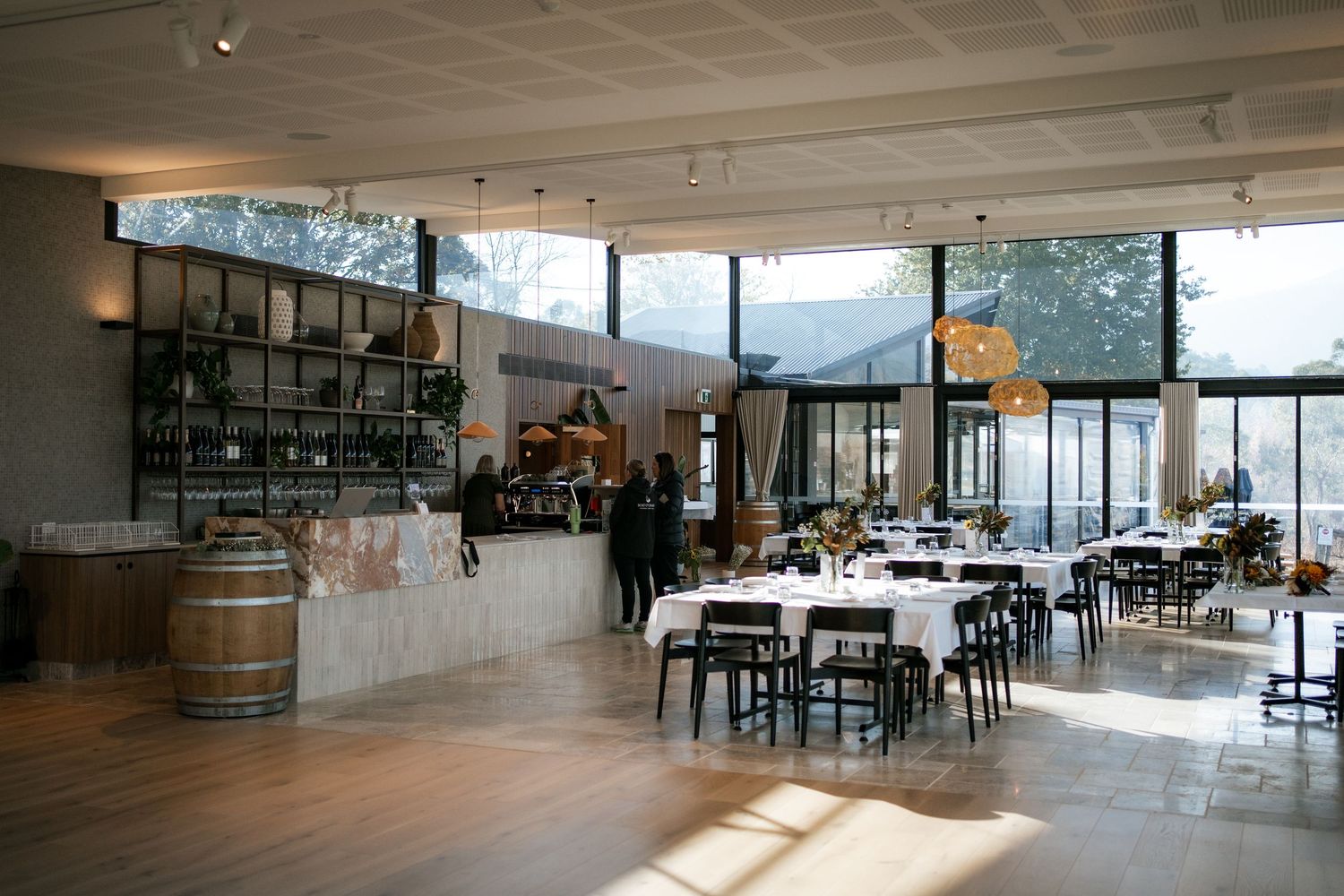 Modern reception venue interior with large windows and barrel decor.
