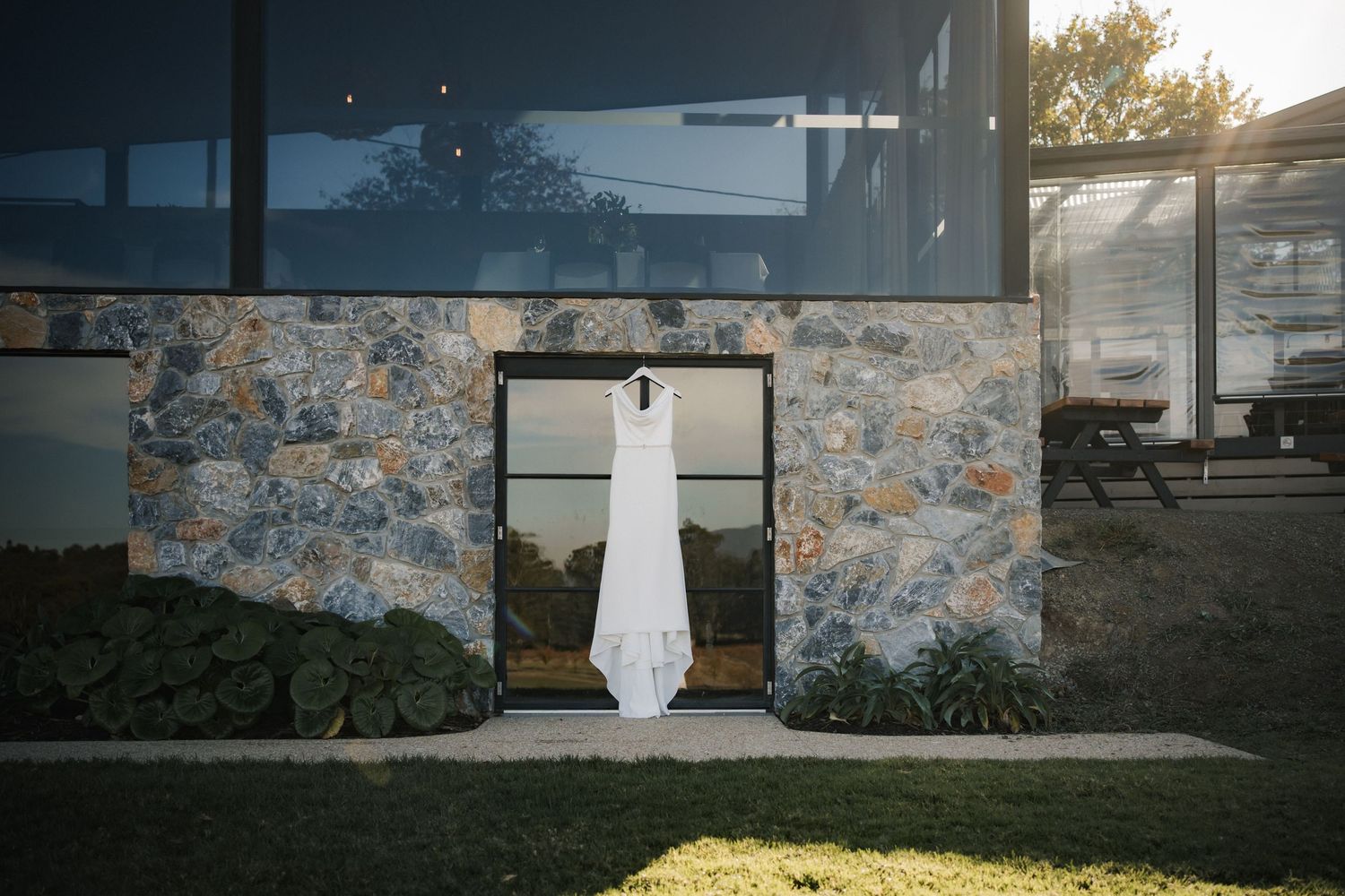 Contemporary stone and glass winery building exterior at sunset.