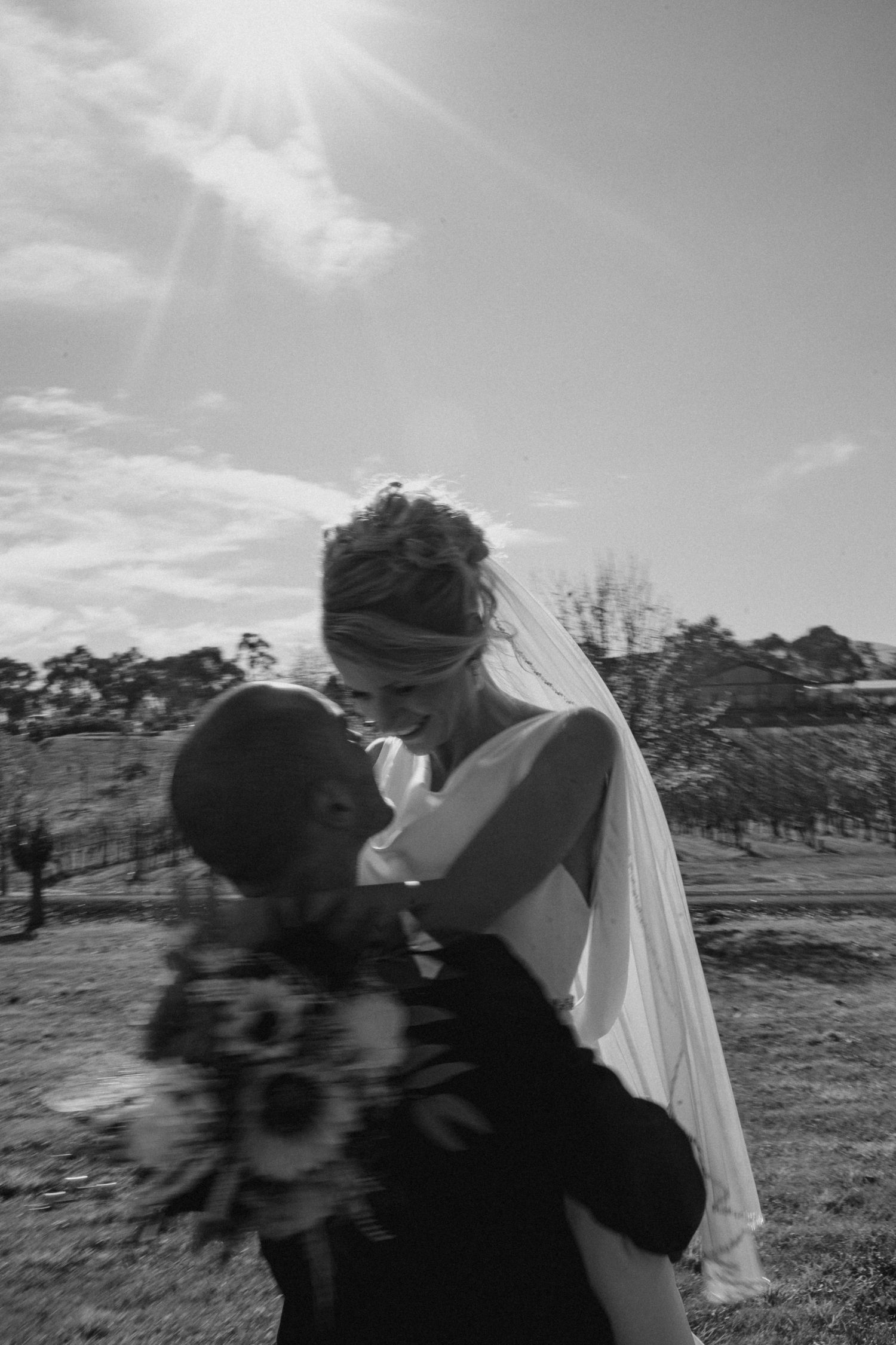 Black and white portrait of romantic wedding couple embracing outdoors.
