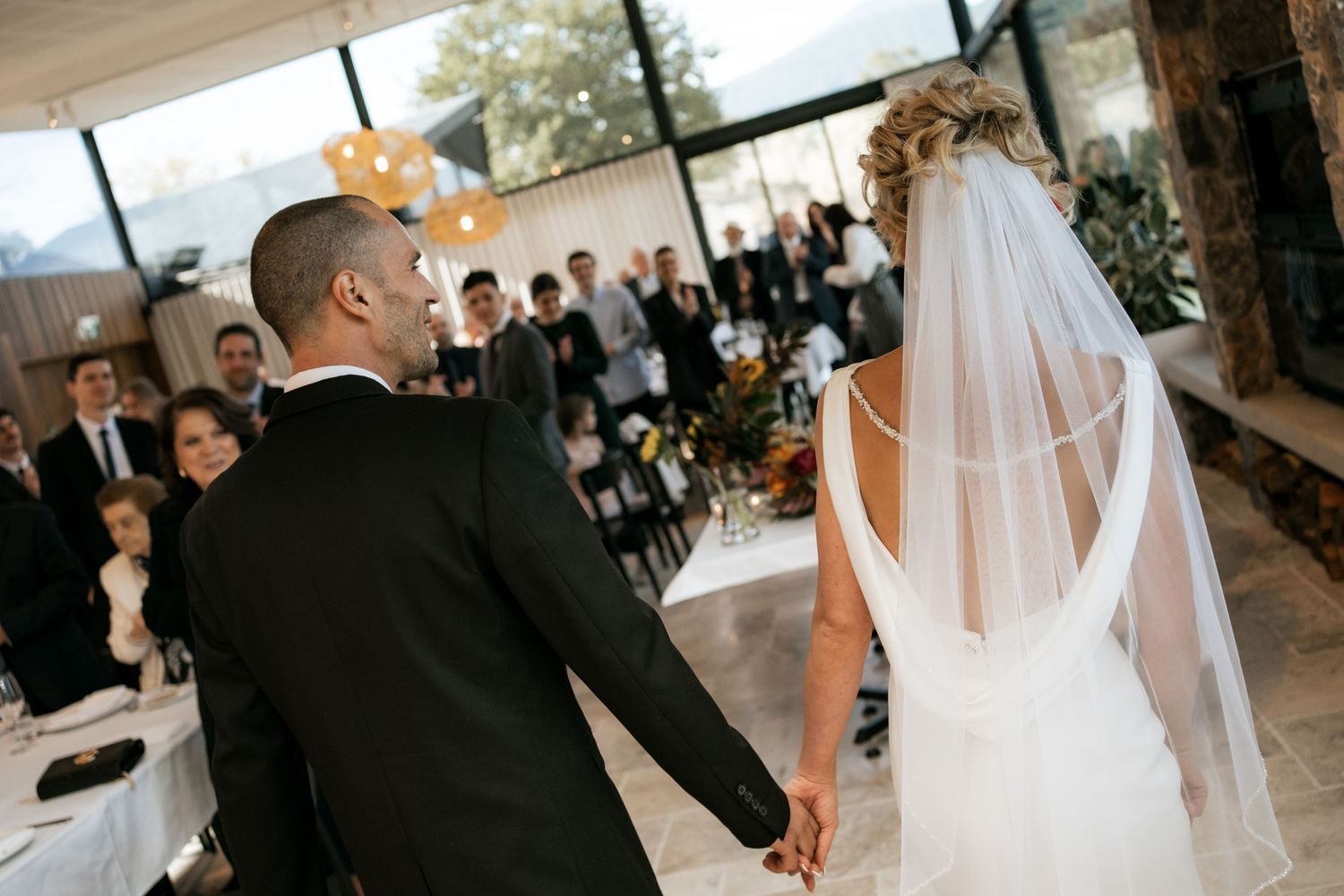 A wedding couple sharing their first dance at their reception surrounded by guests.