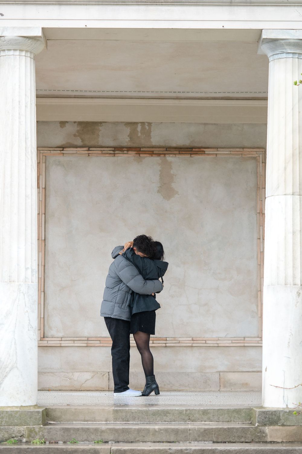 A couple embraces intimately after their proposal in the Untermyer Gardens
