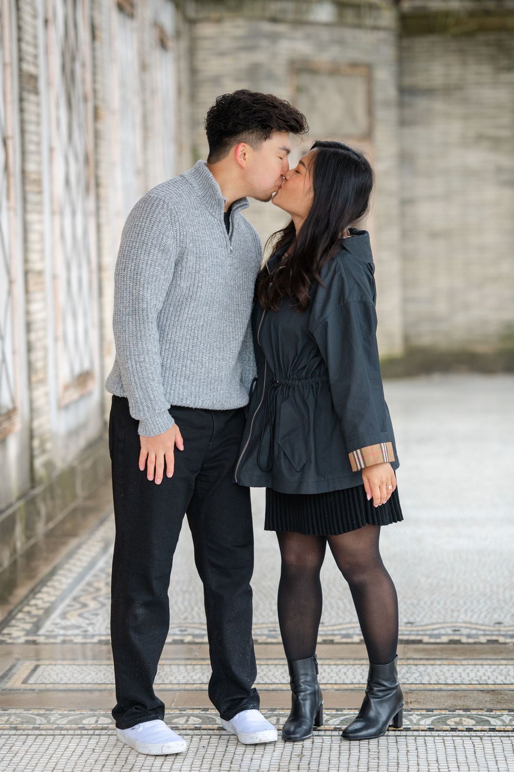 A couple shares a tender kiss while standing in an ornate architectural corridor in Untermeyer Gardens in Westchester near nYC