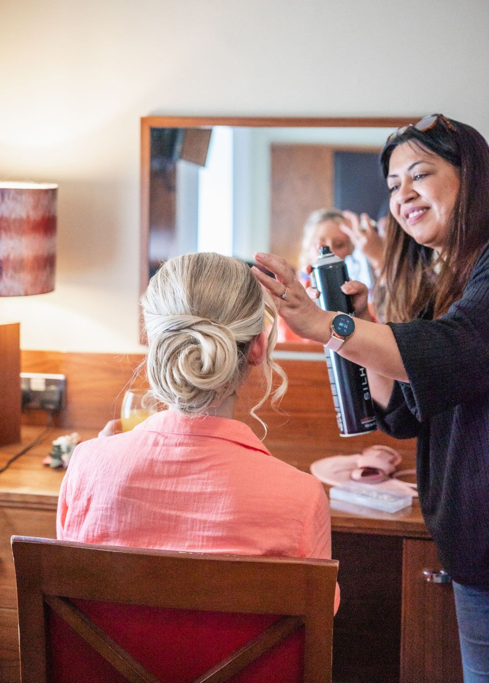 Hair styling session in progress with professional stylist working on elegant updo.