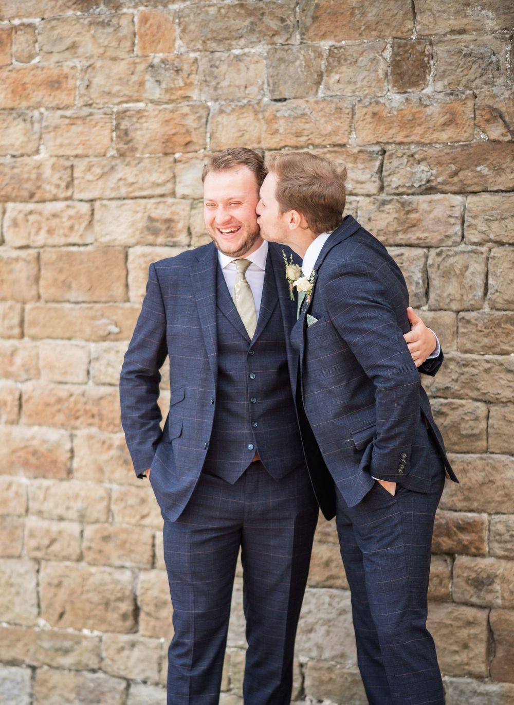 Happy newlyweds walk through shower of confetti with guests celebrating.