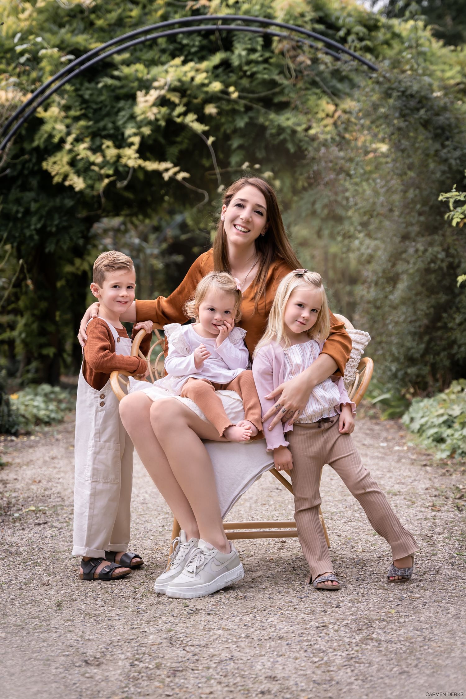 fotoshoot van moeder met drie kindjes op buitenlocatie dromerige sfeer