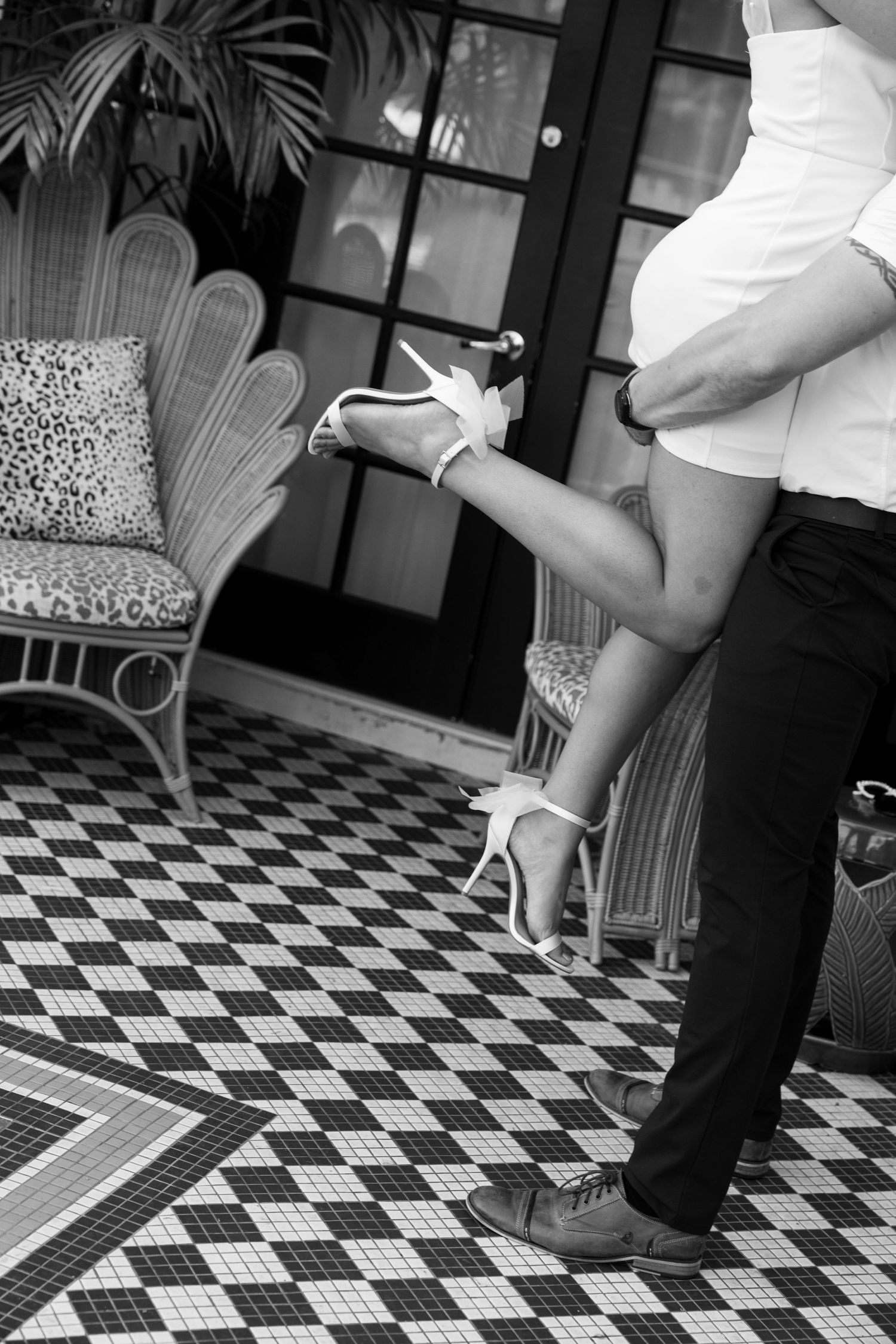 Black and white detail shot of feet and legs against geometric tile floor pattern. Engagement Session at The Lafayette Hotel in San Diego.