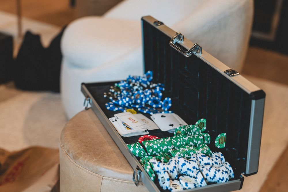A black case filled with blue and green poker chips on display at an event.