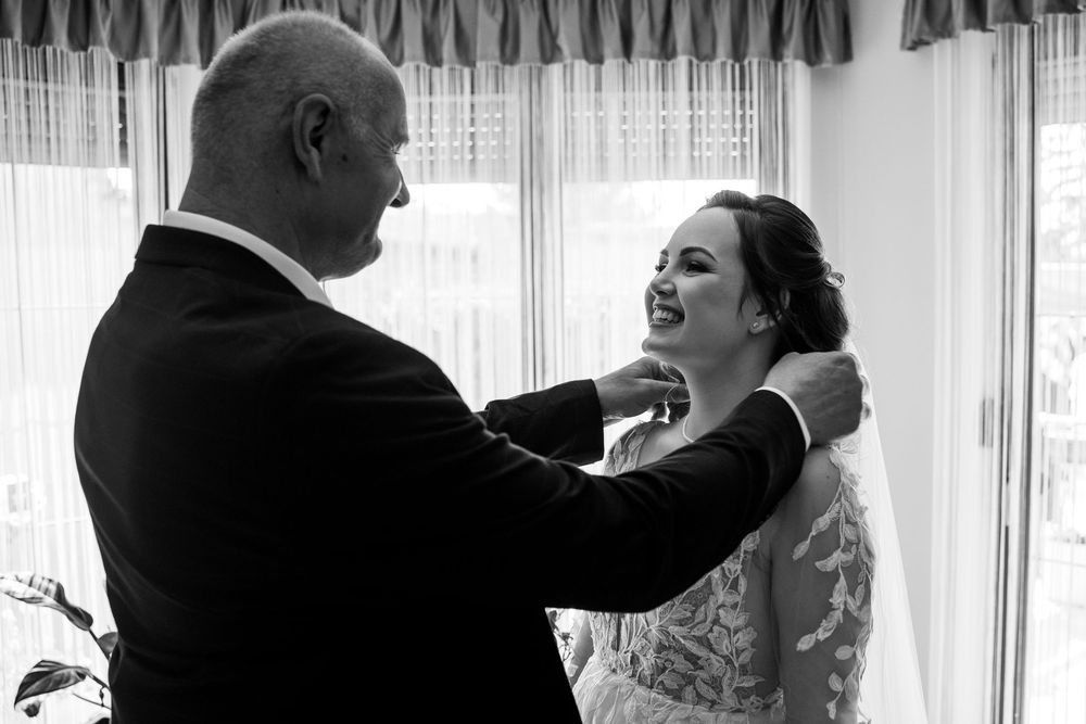 A tender black and white moment captured during an emotional wedding day scene with a bride and her family member.
