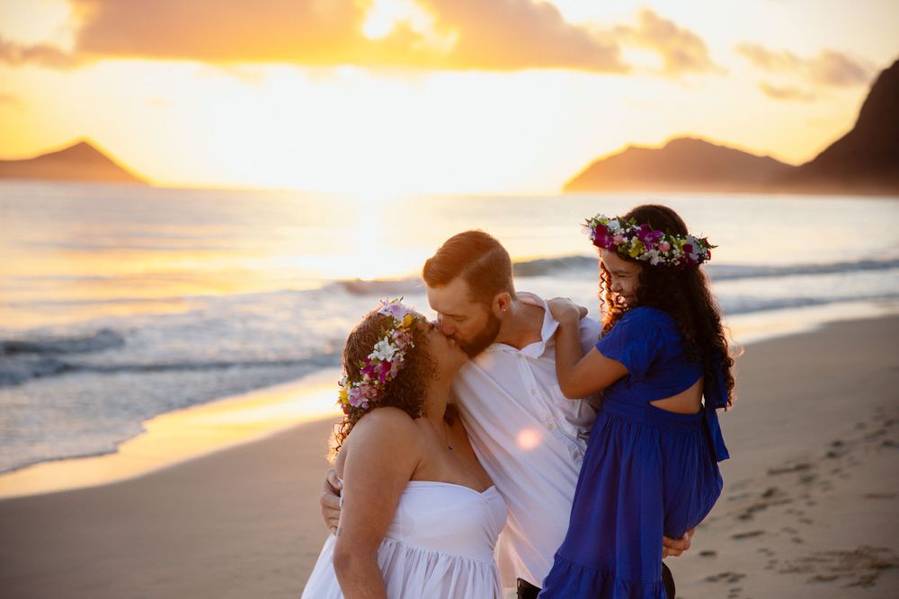People sharing a moment on the beach during a golden sunset with mountains in the background.
WAIMANALO PHOTO SESSION
