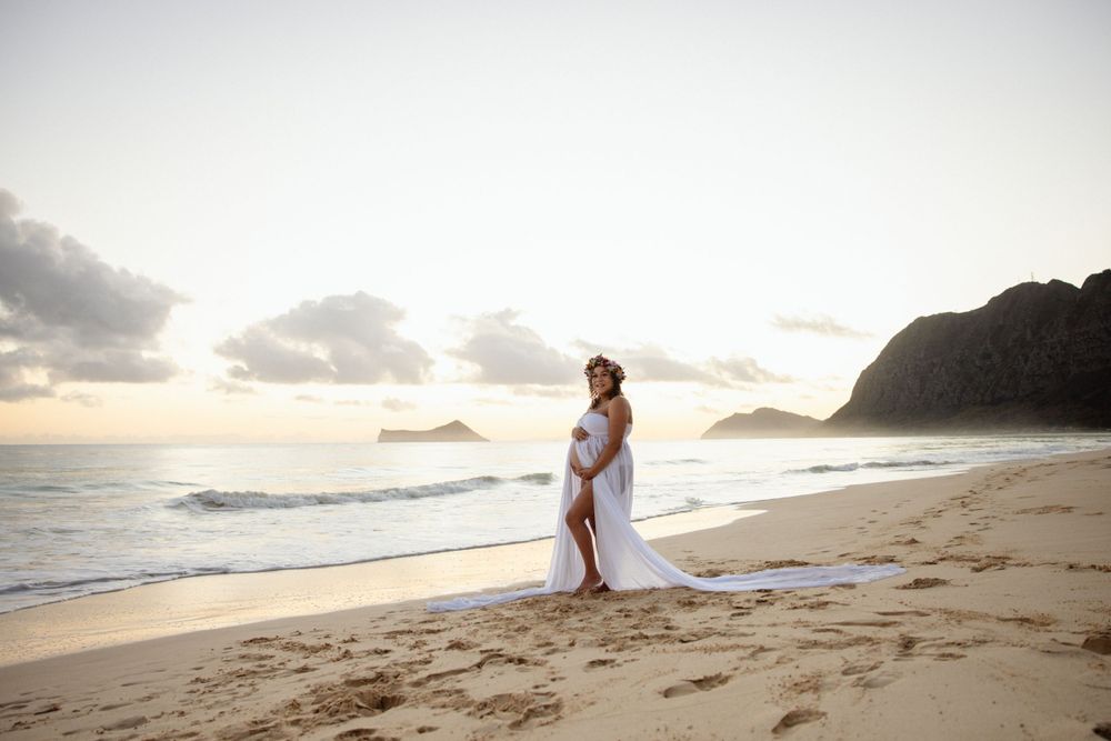 A person in white stands on a sandy beach during golden hour with mountains in the background.
WAIMANALO PHOTO SESSION