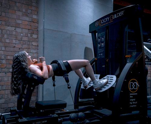 Person exercising on decline bench at gym with industrial brick wall backdrop.