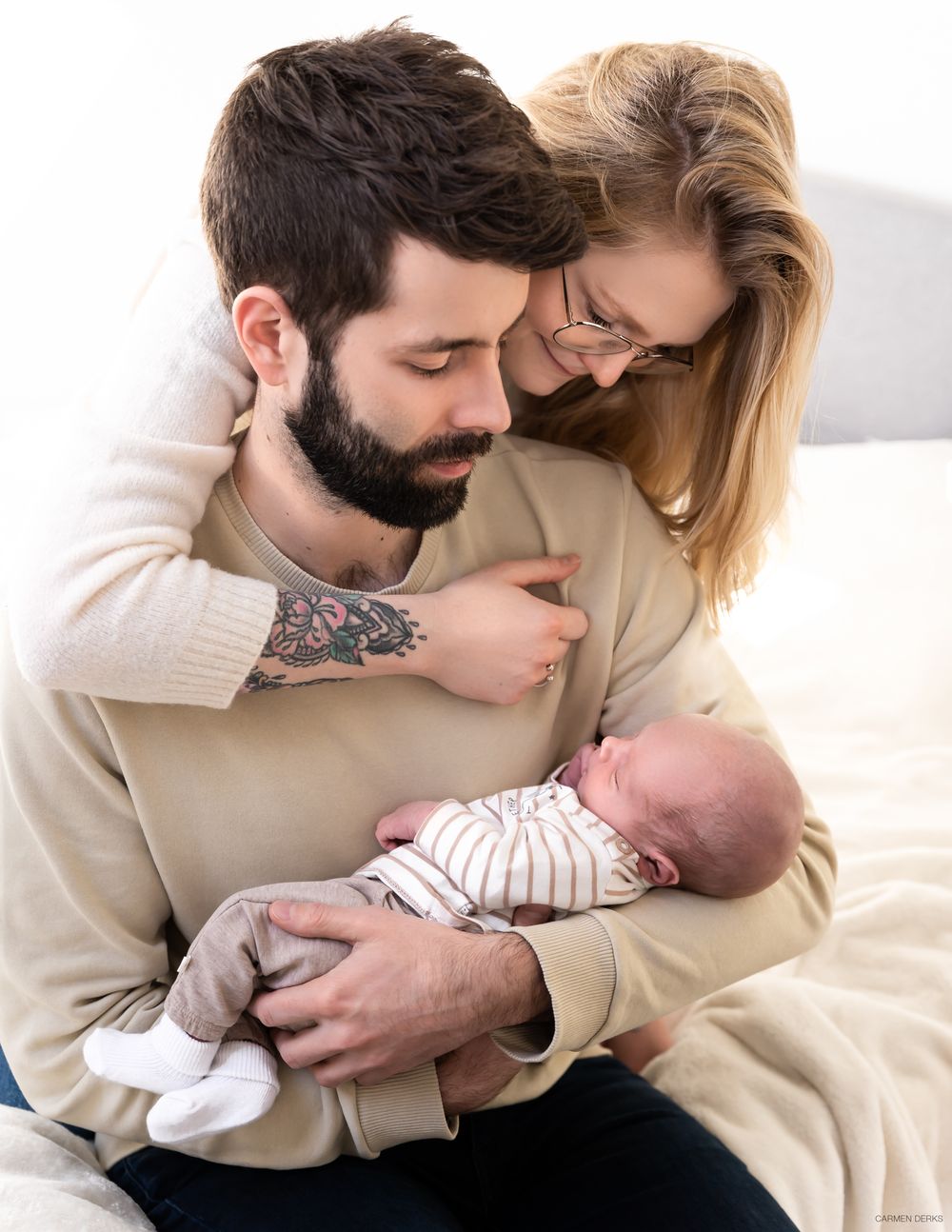 newbornshoot in huiselijke sfeer, vader houdt pasgeboren baby vast, vader en moeder kijken liefdevol naar baby gefotografeerd in maas&waal