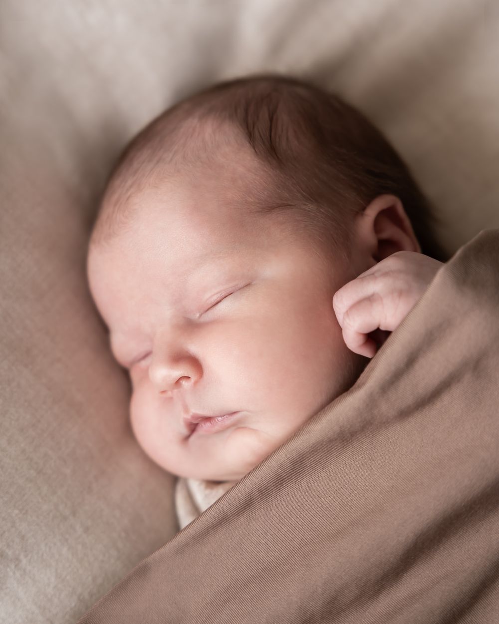 newbornshoot van een pasgeboren baby, vastgelegd in zachte warme beige tinten. in een huiselijke sfeer. gefotografeerd in beneden-leeuwen