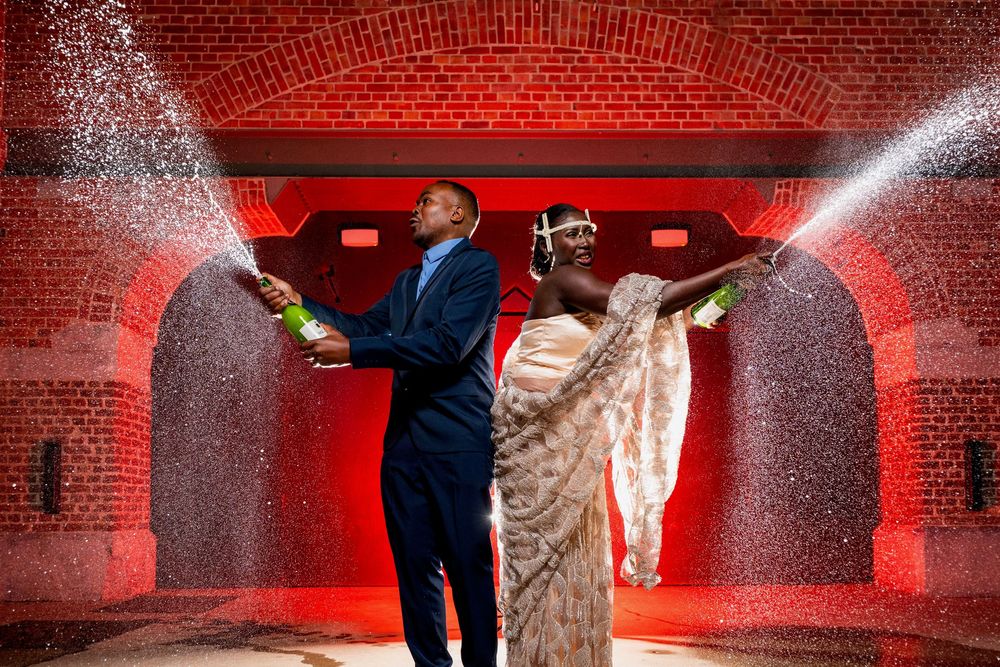 Mariés célébrant leur mariage de nuit avec champagne dans un tunnel éclairé en rouge à l'Espace 58 à Verviers