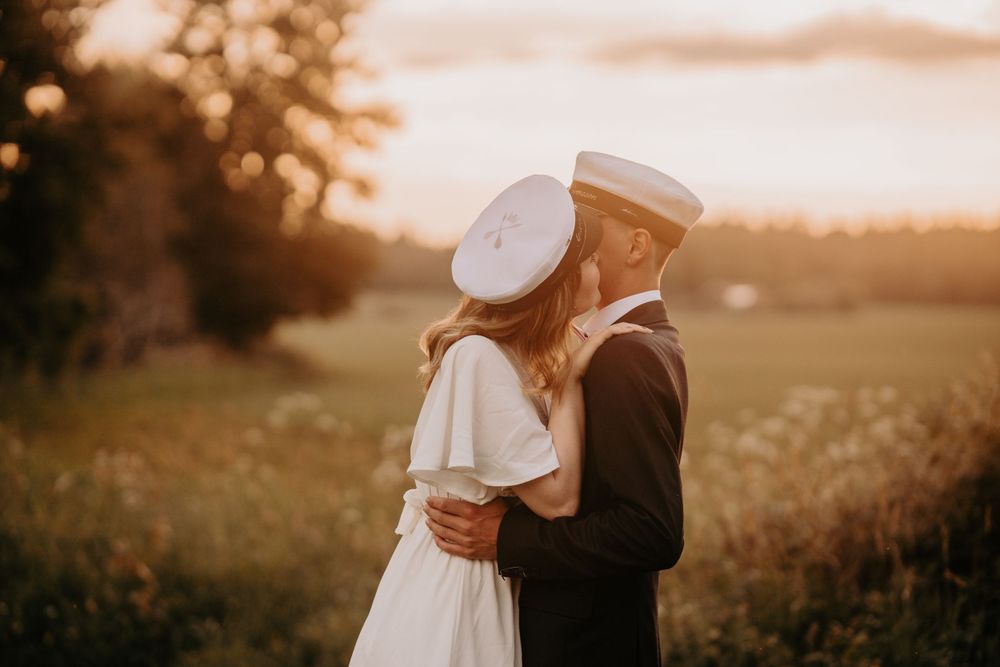 A romantic embrace captured during golden hour in a peaceful meadow setting.