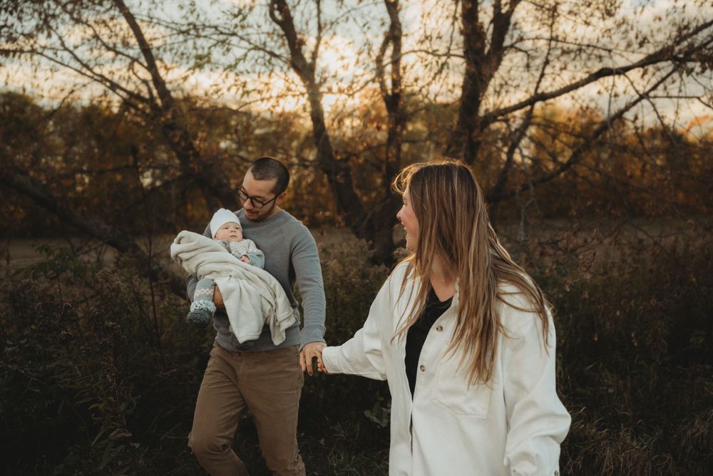 Playful family moment captured during golden hour in a rustic outdoor setting.