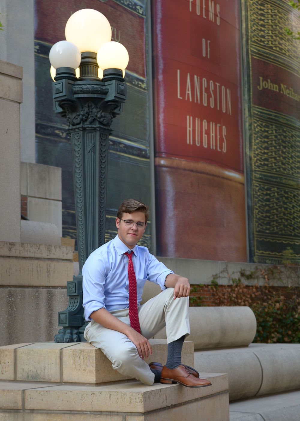 Classic formal portrait by vintage lamppost with business attire and architectural backdrop.