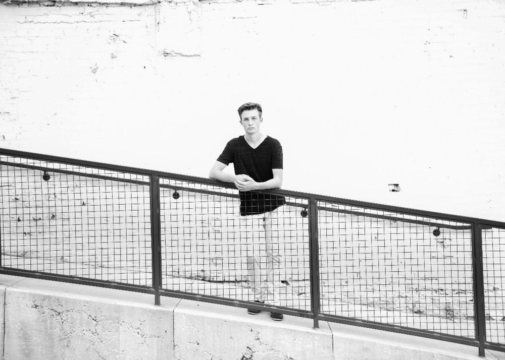 Black and white architectural portrait with metal railing and minimalist composition.
