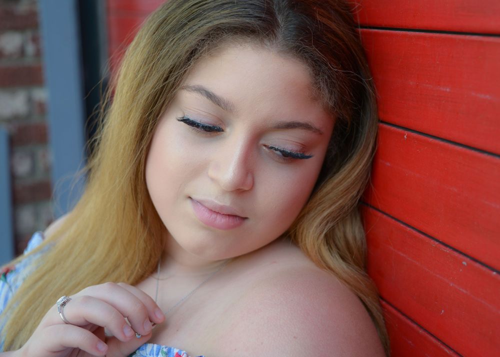 Soft portrait against vibrant red wooden wall background.